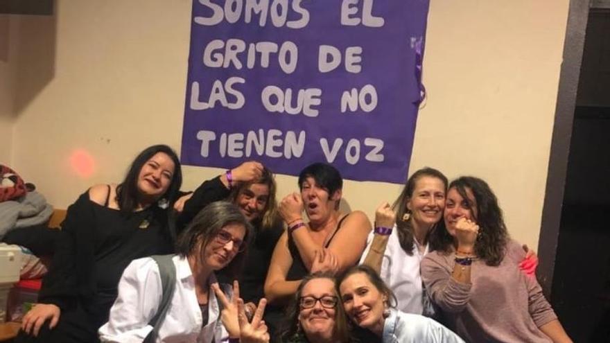 Silvia, Paula y Cristina, junto a las &quot;taberneiras&quot; y bajo una de las pancartas colocadas en el local.