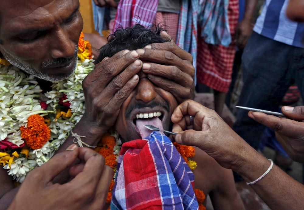 La lengua de un hindú es perforada por un pincho de metal en el festival anual Shiva Gajan en Bengala del Oeste, India.