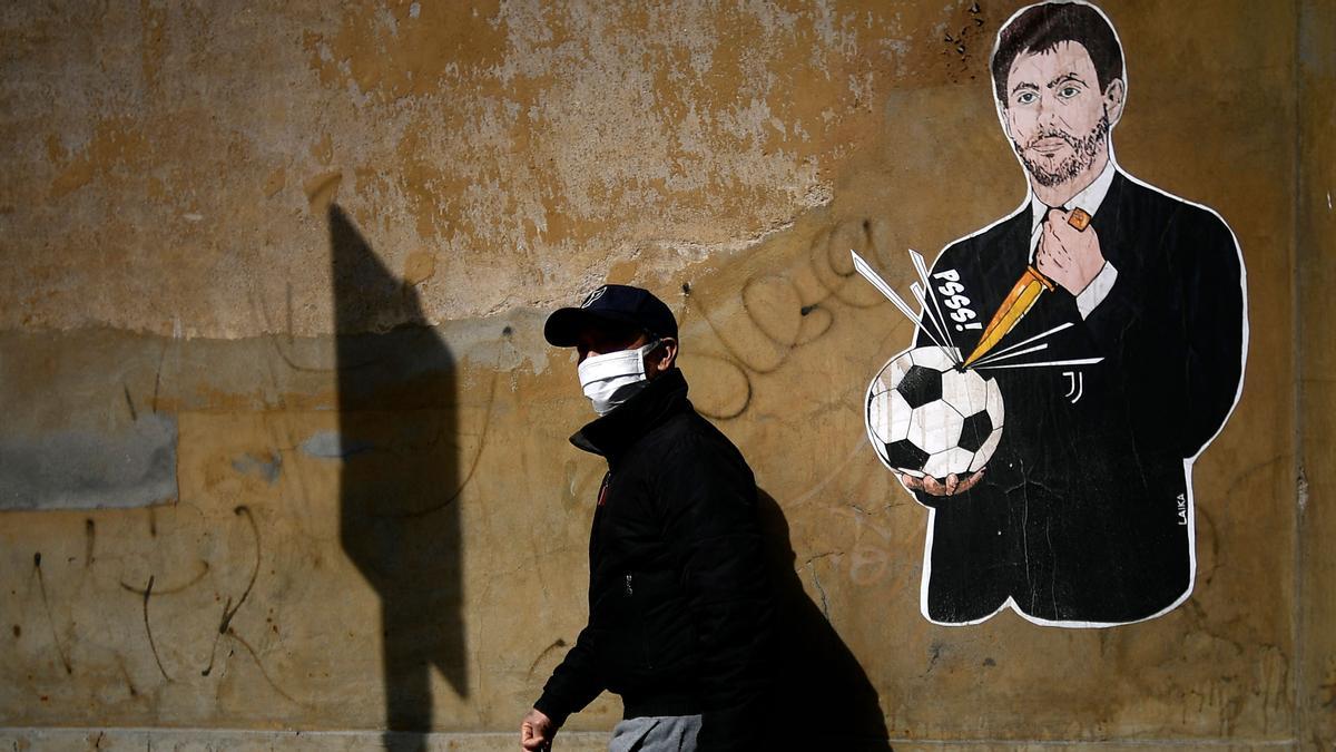 Un hombre pasea por Roma junto a un grafiti de Agnelli pinchando un balón, la pasada semana cuando estalló la polémica de la Superliga.