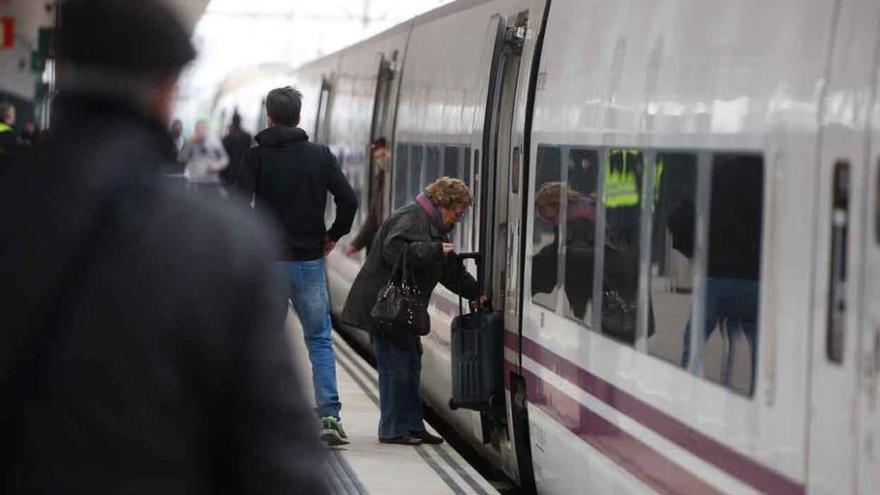 usuarios del ferrocarril montan en uno de los Alvia procedentes de Galicia que estrenaban ayer la línea AVE hacia Madrid.