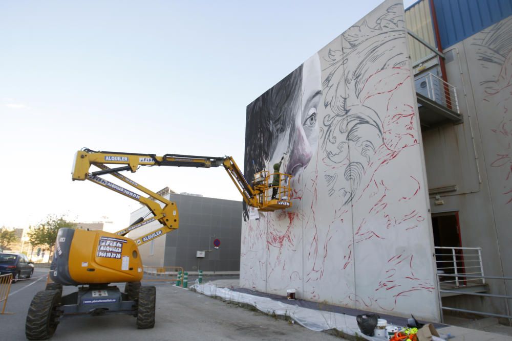 Lula Goce pinta un mural en la fachada de Bellas Artes de la UMU