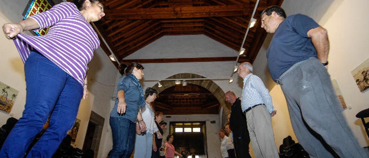 Los alumnos de baile canario ensayan algunos pasos en la ermita.