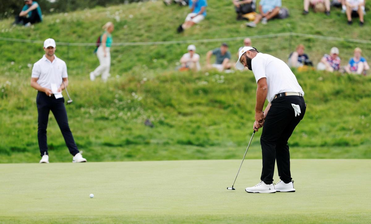 Rahm patea ante la mirada de su compañero de juego, el balga Thomas Detry