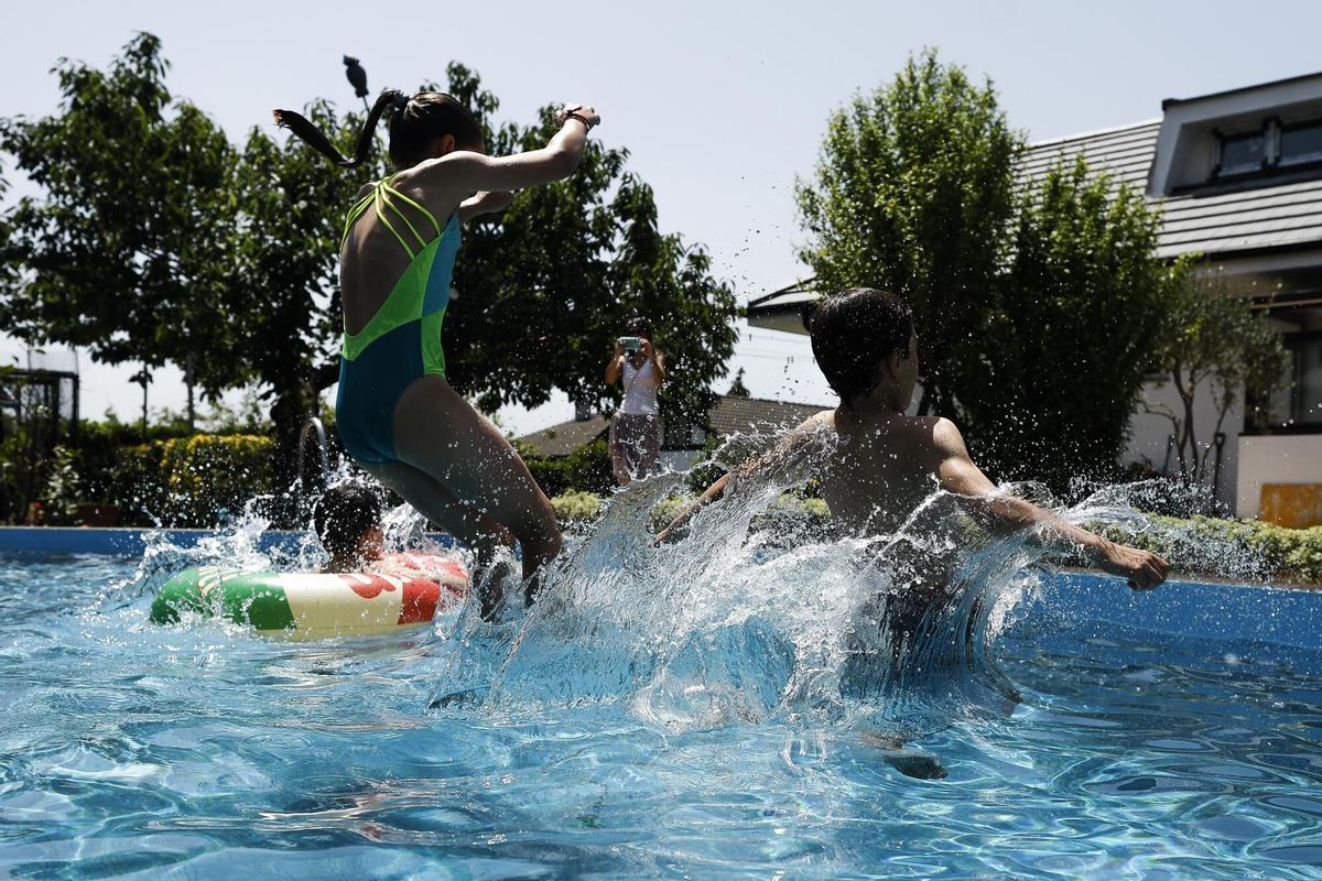 FOTODELDÍA - BERANGO (BIZKAIA), 21/06/2026.- Tres jóvenes se refrescan en una piscina en Berango (Bizkaia) este domingo, jornada en la que el Departamento vasco de Seguridad ha elevado la alerta a roja por la ola de calor al esperarse temperaturas muy altas que alcancen los 40 grados. EFE/Miguel Toña