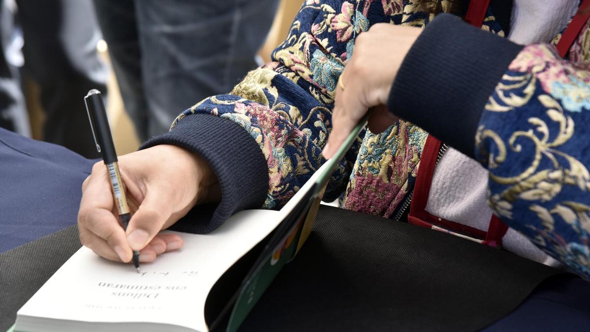 Una escritora firma un libro en Barcelona durante la festividad de Sant Jordi.