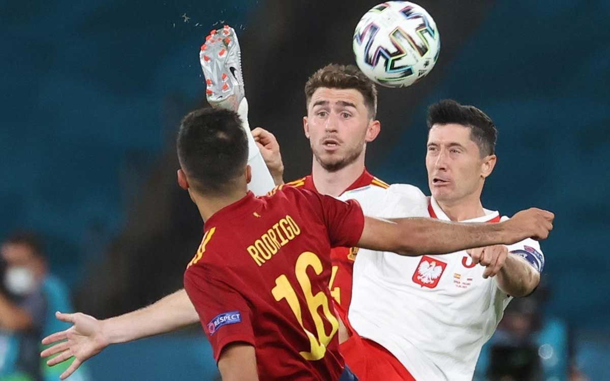 Lewandowski pugna por un balón ante la presión de Rodri y Laporte.