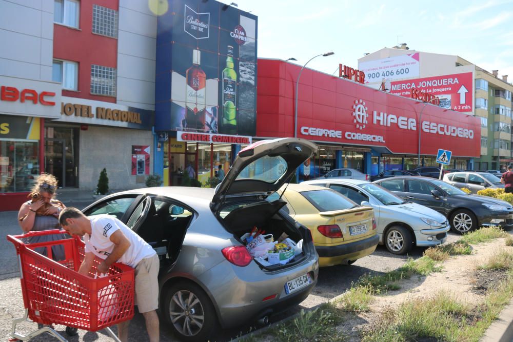 Clients francesos carreguen el cotxe després de comprar a la Jonquera