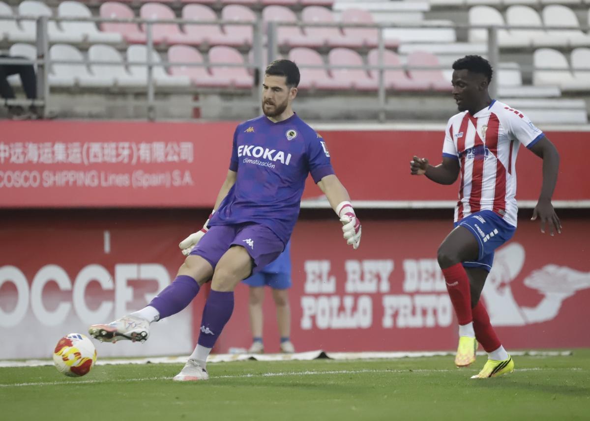 Carlos Abad saca un balón desde su porteria presionado por el atacante del Algeciras Isaac Obeng.