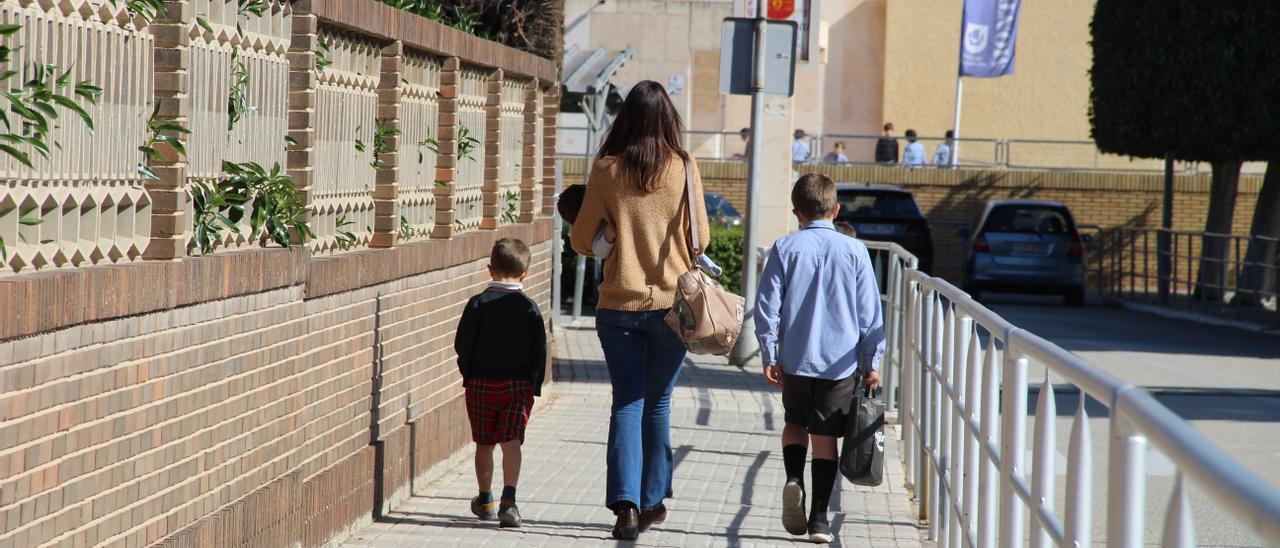 Una madre y alumnos, ayer en las inmediaciones del colegio Monteagudo de Murcia.