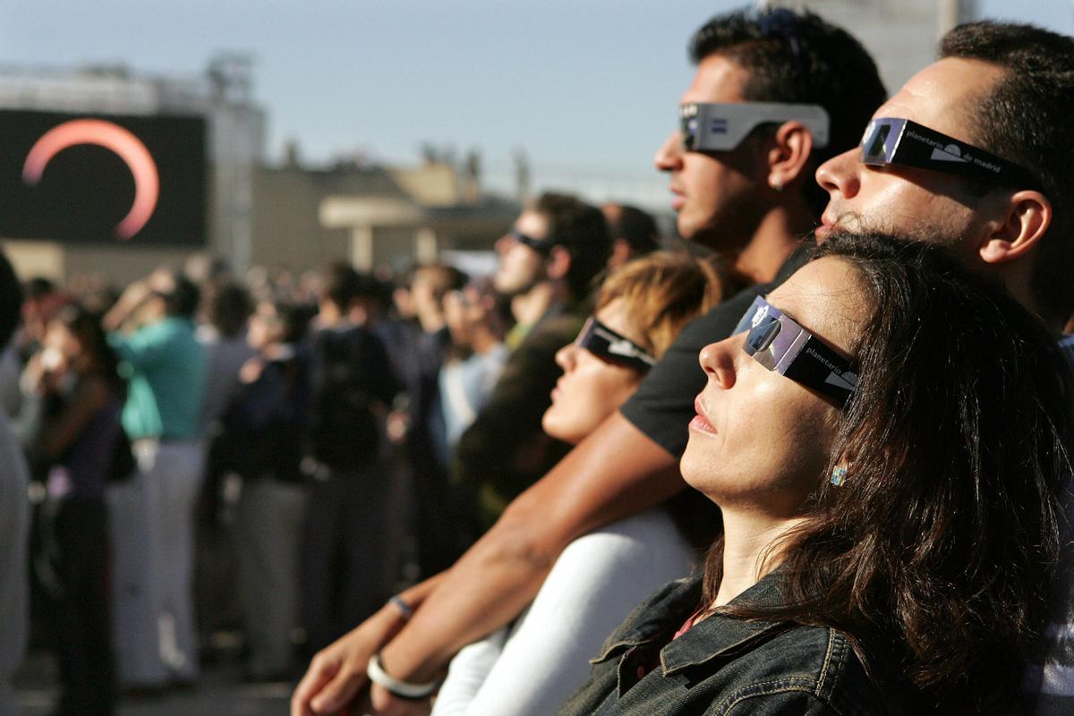 Varias personas observan el eclipse anular de 2005 en el Planetario de Madrid.