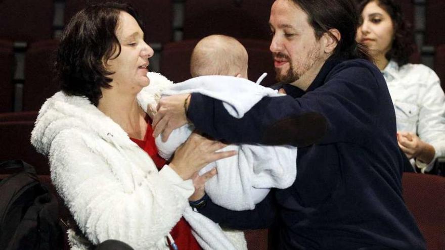 Pablo Iglesias, a la derecha, coge en brazos al hijo de Carolina Bescansa, en el cine.