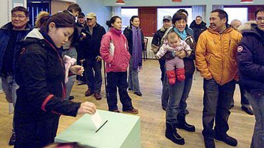 Una joven deposita su papeleta en una urna en Nuuk, Groenlandia, durante el referéndum que se celebró ayer.