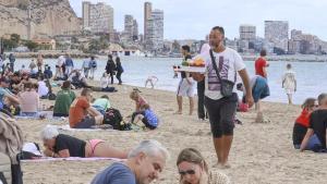 Un vendedor ambulante ilegal de bebidas en la playa del Postiguet.