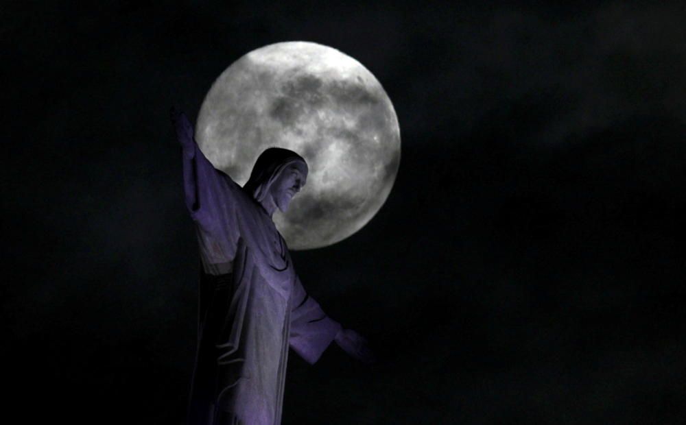 The full moon shines behind the Christ the ...