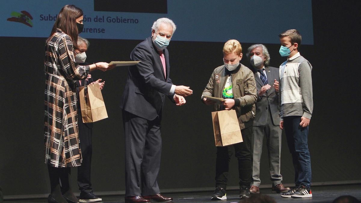 Dos de los escolares, recogiendo su premio de la mano del presidente del Parlamento.