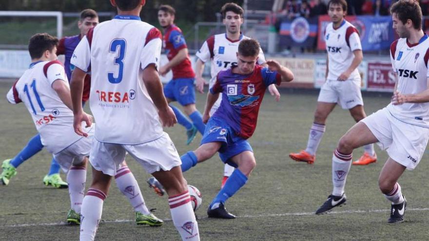 Cayarga protege el balón ante cuatro futbolistas del Roces.