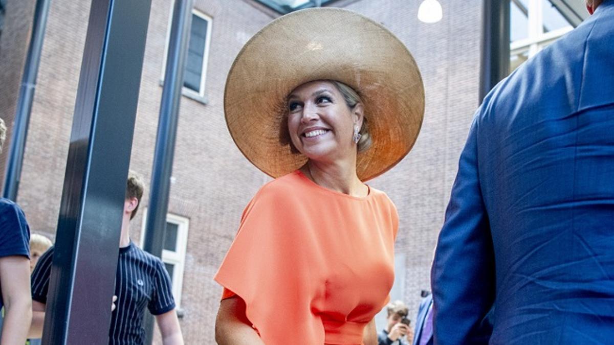 Máxima de Holanda combina un vestido naranja estilo 'wrap' con su pamela de rafia preferida