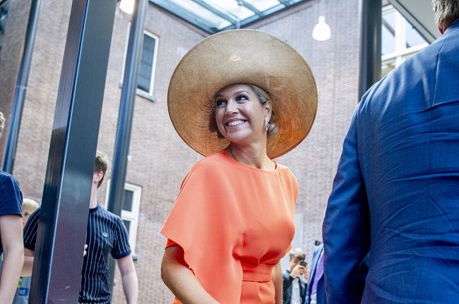 Máxima de Holanda combina un vestido naranja estilo 'wrap' con su pamela de rafia preferida
