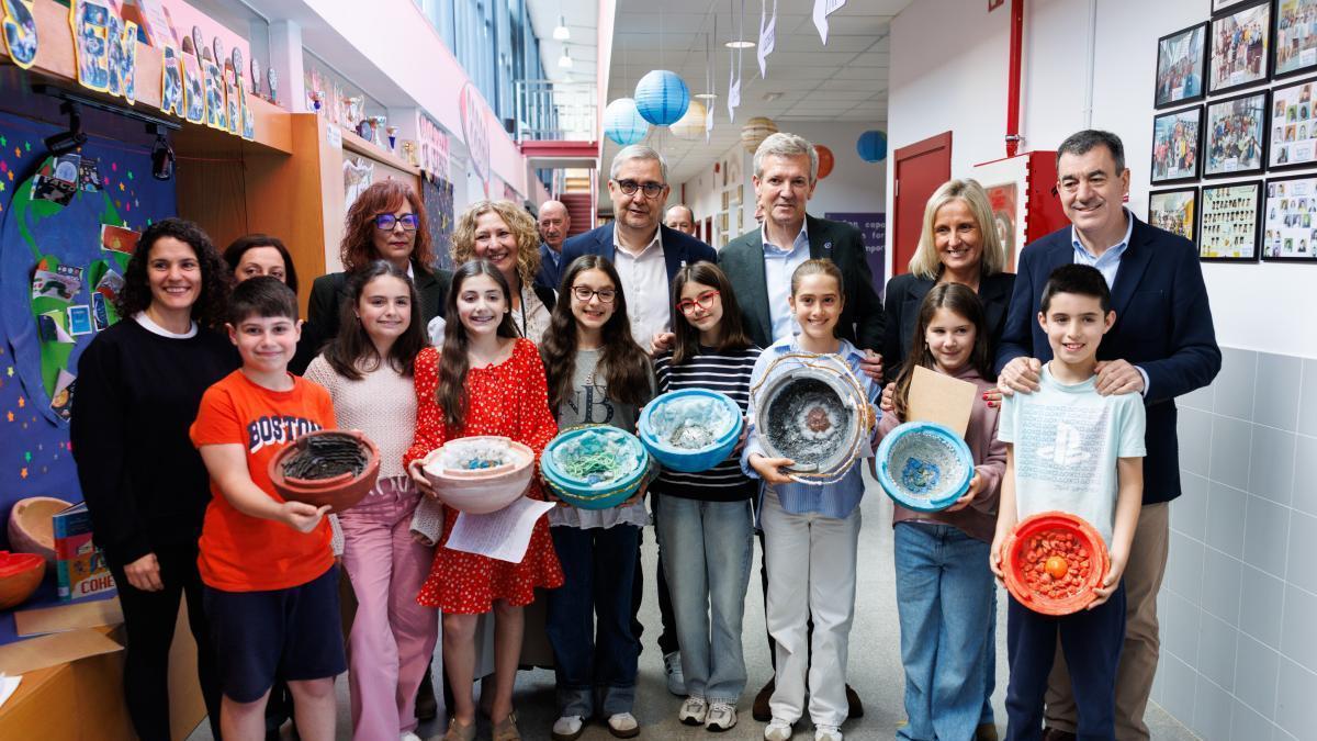 Alfonso Rueda y Román Rodríguez, con el alcalde de Ames, la concejala de Educación, la portavoz del PP amesano, la directora del CEIP Agro do Muíño, personal del centro y alumnos de 5º de Primaria