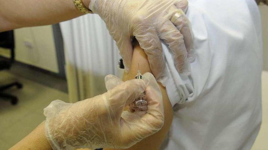 Un profesional sanitario administra una vacuna contra la gripe.