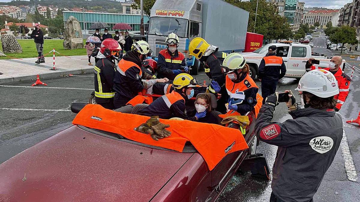 Efectivos de Emerxencias y Protección Civil rescatan a la conductora del coche.