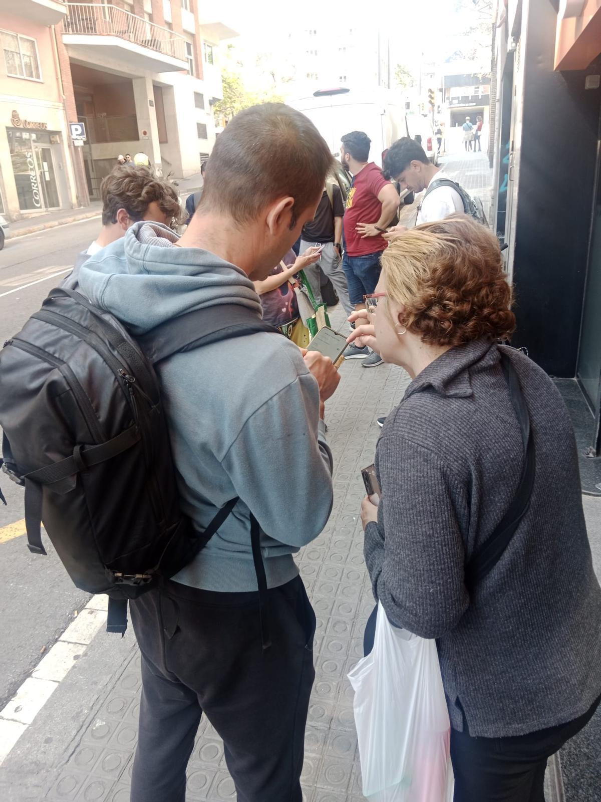 Pilar, de espaldas, ayuda a un recién llegado a conectarse al wifi.