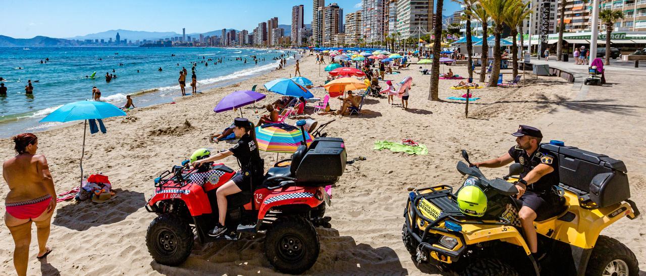 Dos agentes de la Policía Local patrullan las playas de Benidorm, en una imagen del pasado verano.