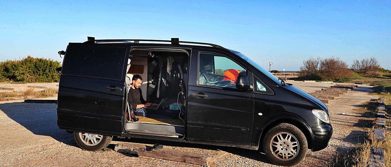 Un usuario de una furgoneta «camper» en una playa del Saler, ayer. | JOSÉ MANUEL LÓPEZ