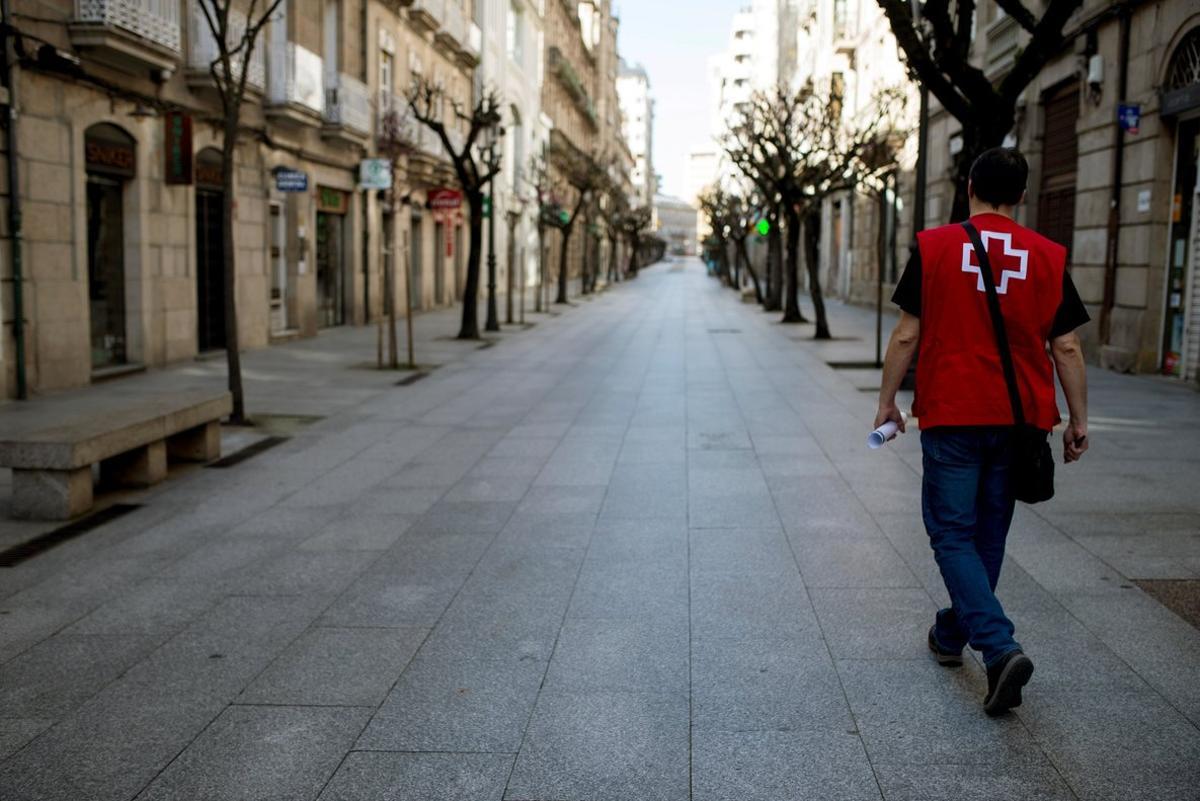 GRAF8292. OURENSE, 17/03/2020.- Un miembro de la Cruz Roja recorre la calle de Paseo de Ourense completamente vacía. En Galicia los infectados con coronavirus ascienden este martes a 285. EFE//Brais Lorenzo