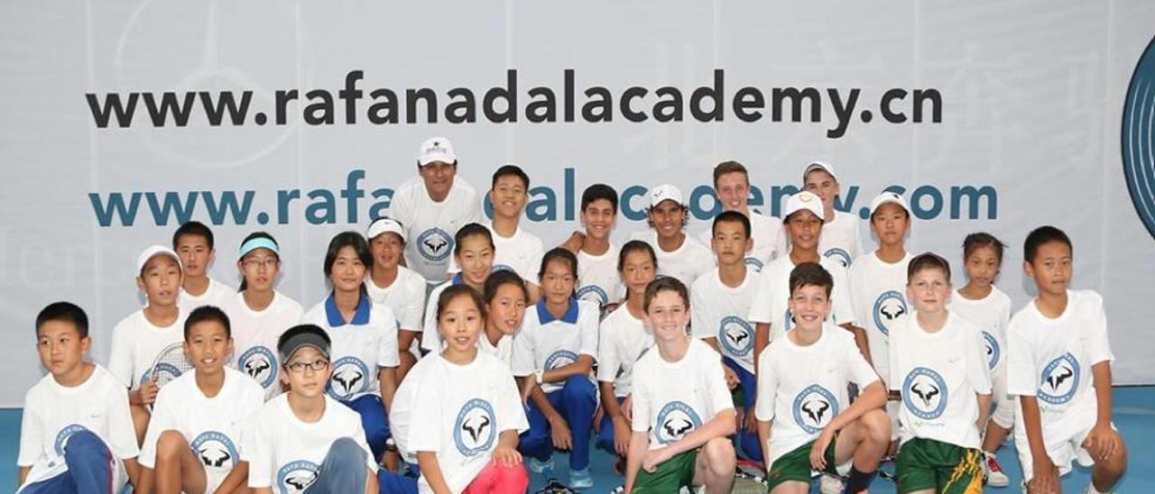 Rafel Nadal y su tío Toni, posando junto a un grupo de niños chinos, futuros aspirantes a formar parte de la academia de Manacor.