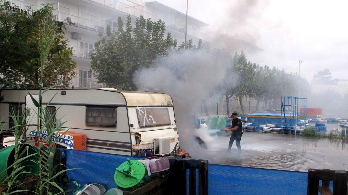 Un agente de la Policía Nacional trata de extinguir el fuego en el cuadro eléctrico