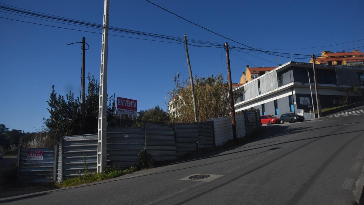 Á esquerda, vallas do terreo que pretende adquirir o Concello para construír o novo centro de saúde.