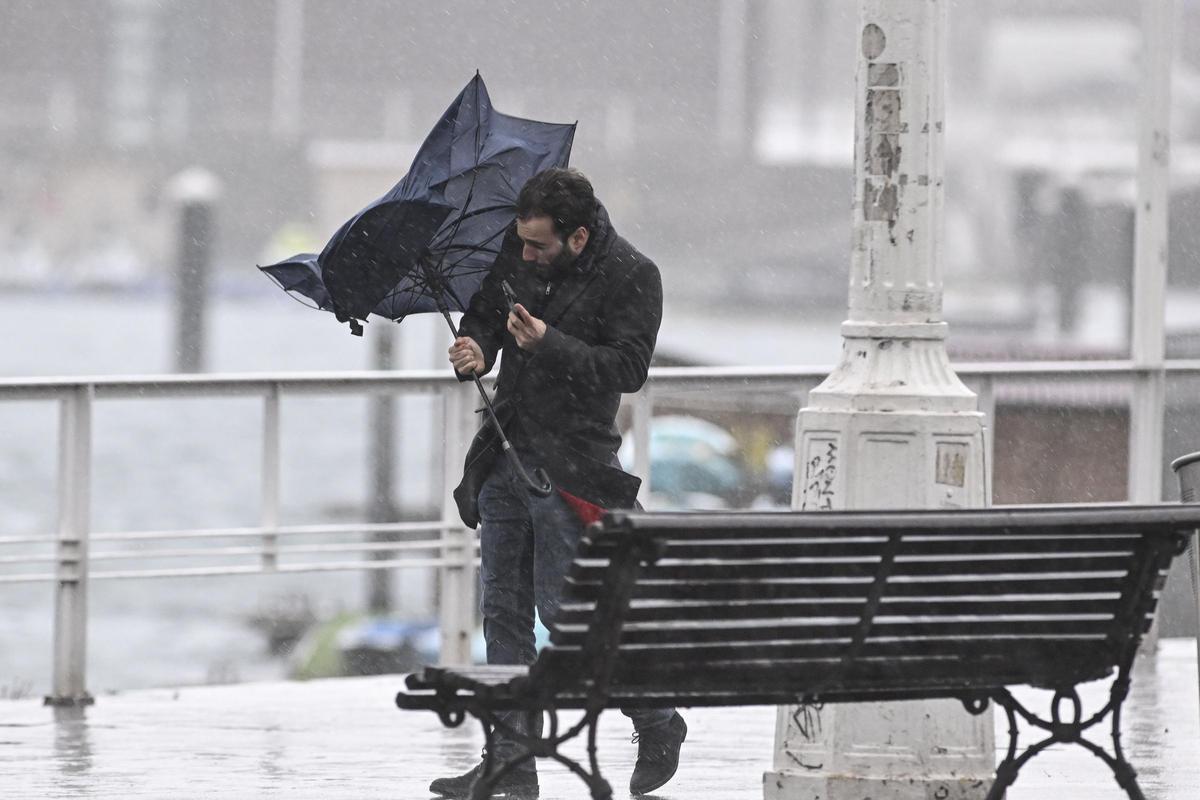 Un hombre lucha contra el viento, este viernes, en Gijón.