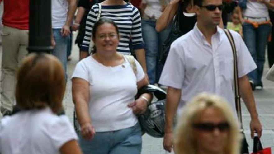 Un grupo de personas pasea por la calle.