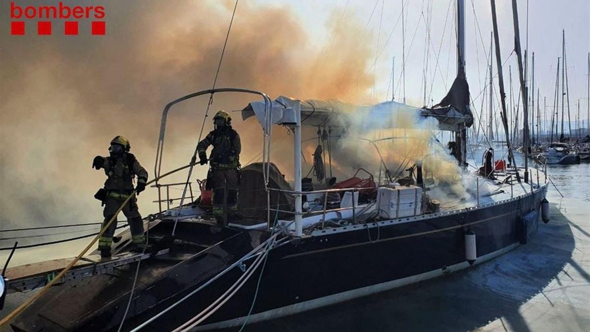 Los Bombers de la Generalitat realizan tareas de extinción en un incendio en un barco del Port de Badalona.