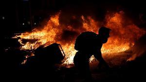 Un manifestante independentista junto a una barricada en llamas, la noche de este martes en el centro de Barcelona.