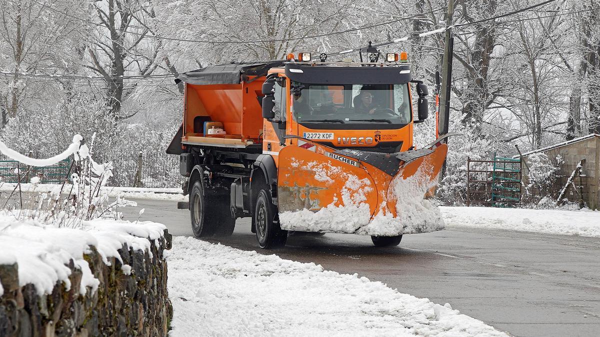 Una máquina quitanieves retira nieve de una carretera.