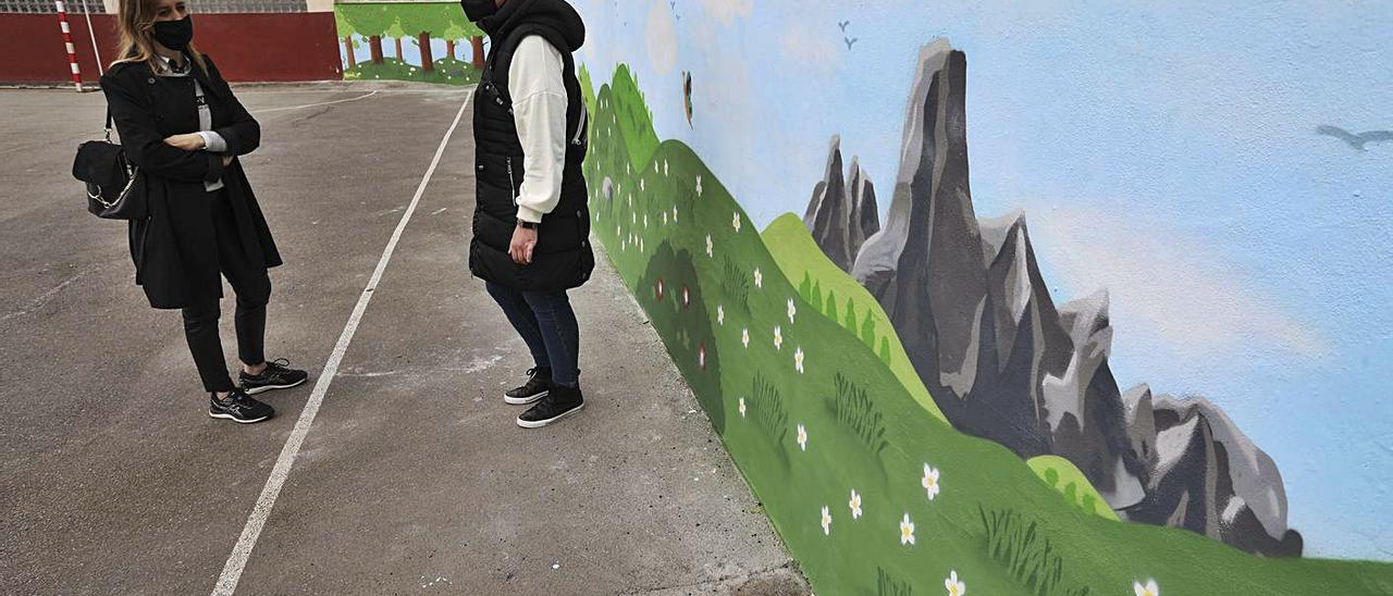 Eva Álvarez y Desirée Medina conversan ante el muro denominado “patio verde” en el colegio de Sabugo. | R. Solís