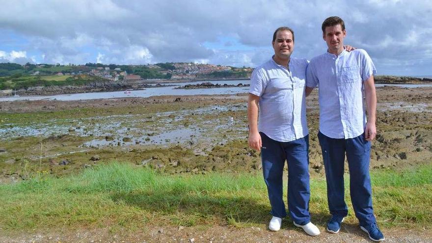 Marcos Martínez Méndez y David Pérez Rodríguez, con la playa y Luanco detrás.