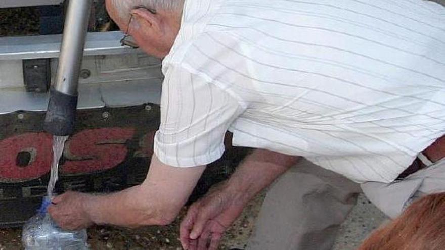 Vecinos se abastecen de agua de un camión cisterna.