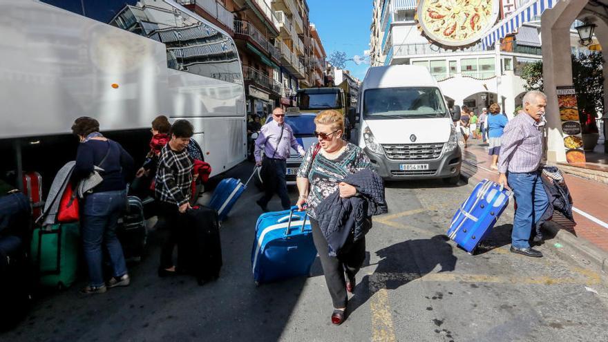 Un grupo de turistas desciende de un autobús.