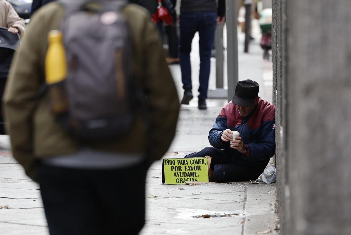 Un hombre pide ayuda en la calle.