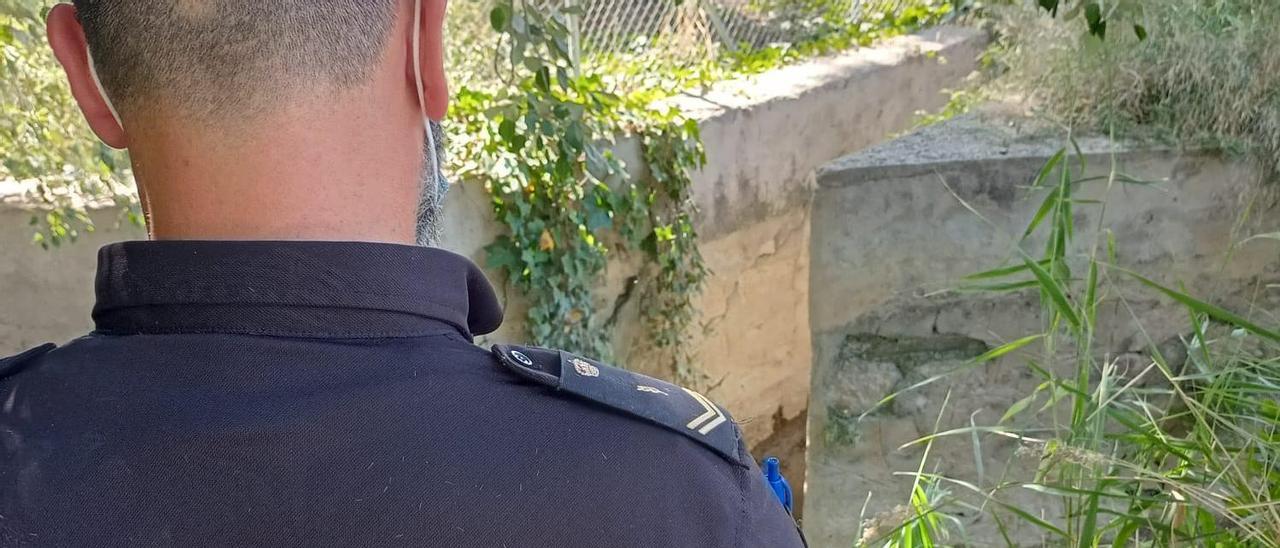 Un agente frente a la acequia donde rescataron a la mujer en Orihuela.