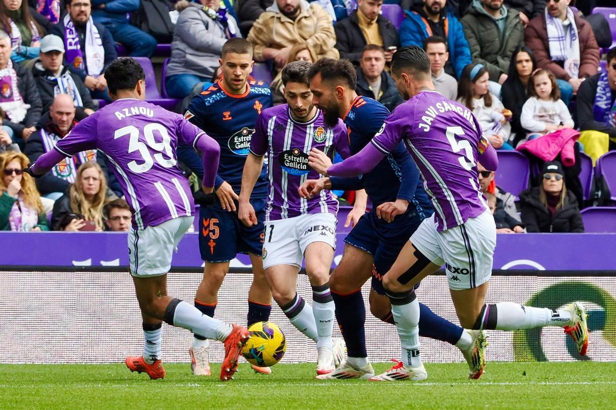 El delantero del Celta de Vigo, Borja Iglesias (c) ante la presión del defensa Javi Sánchez (d) del Real Valladolid durante el partido de Primera División disputado en el estadio José Zorrilla este sábado. EFE/R.García. (Valladolid) (Celta)