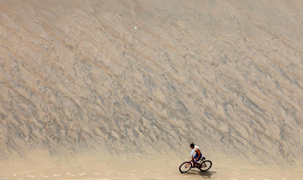 Un joven en bicicleta en la playa de Meireles de Fortaleza, Brasil.