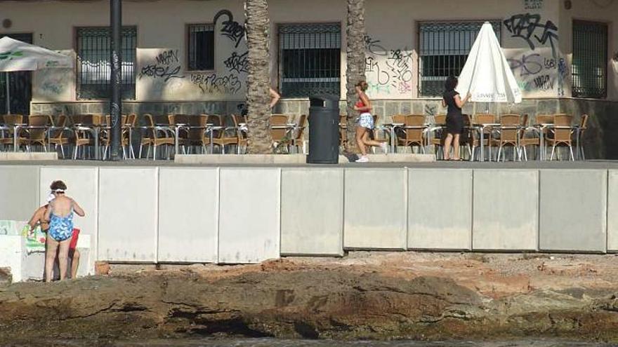 Aspecto del paseo de Juan Aparicio con el mar en primer término, el paseo y las terrazas con sillas y mesas