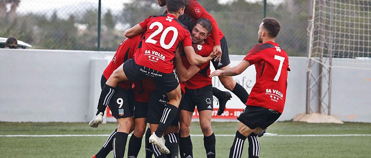 Mena, en lo alto de la piña de los jugadores del Formentera, festeja un gol ante el Sant Rafel.