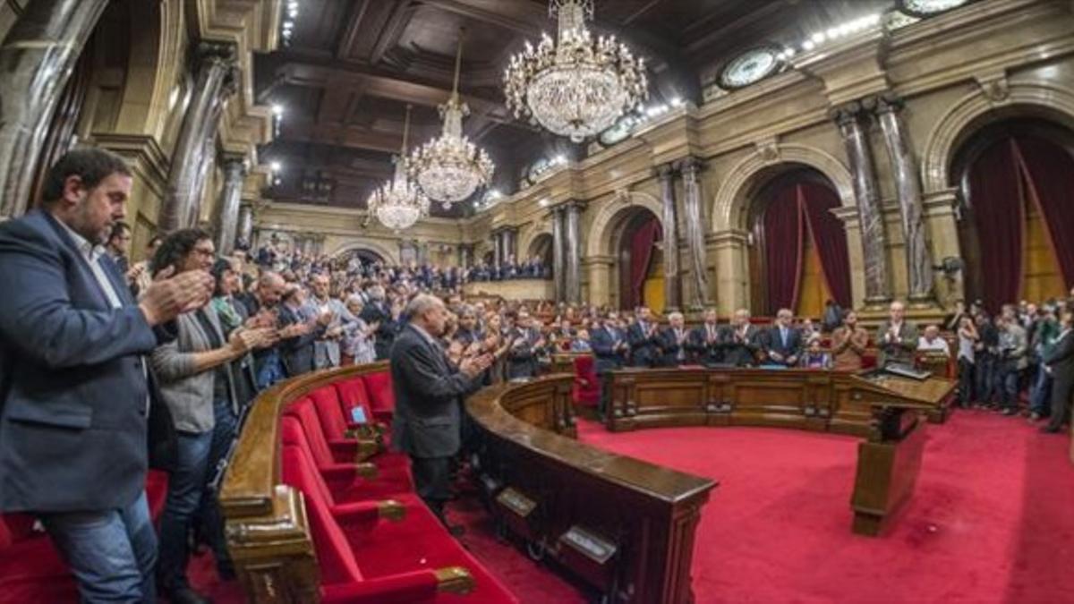 Los diputados independentistas aplauden el primer discurso de Carme Forcadell como presidenta del Parlament mientras los no soberanistas permanecen sentados, ayer.