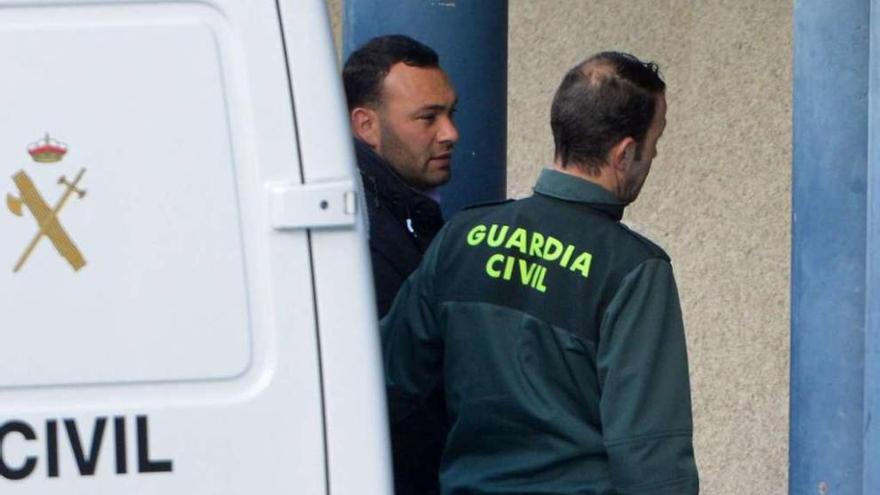 Un agente de la Guardia Civil custodia al detenido, Marcos Vidal, a su llegada a los juzgados de A Parda, ayer. // FdV