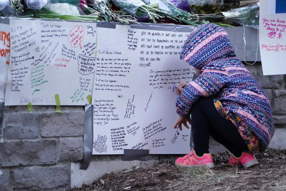 A mourner pays respects at a makeshift memorial ...